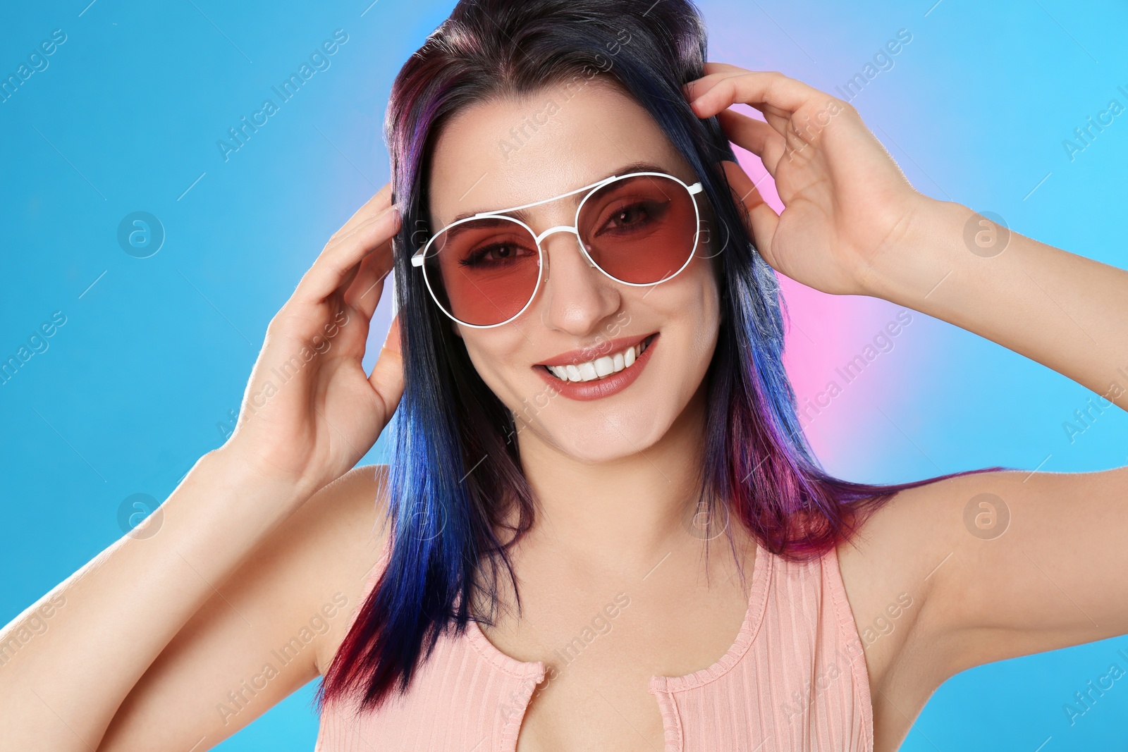 Photo of Young woman with bright dyed hair on color background