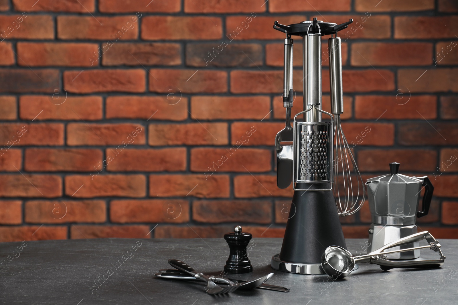 Photo of Set of different kitchen utensils on grey table, space for text