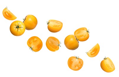 Fresh ripe yellow tomatoes flying on white background