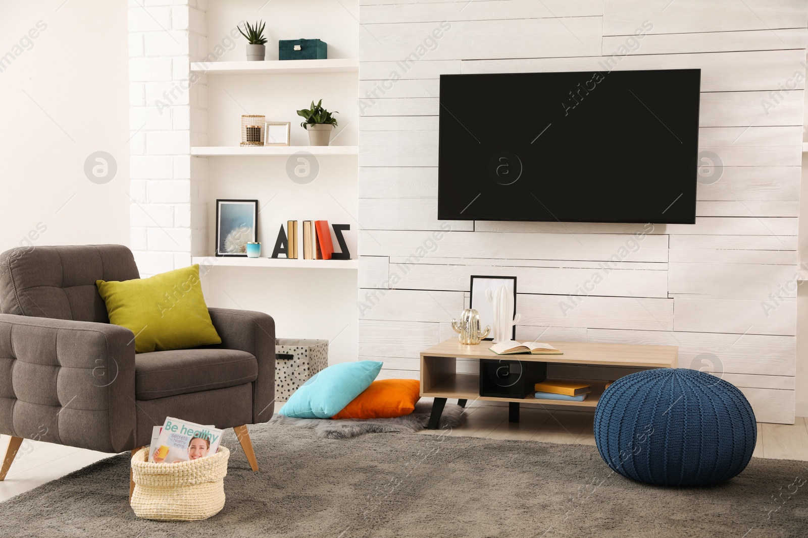 Photo of Cozy room interior with stylish furniture, decor and modern TV set