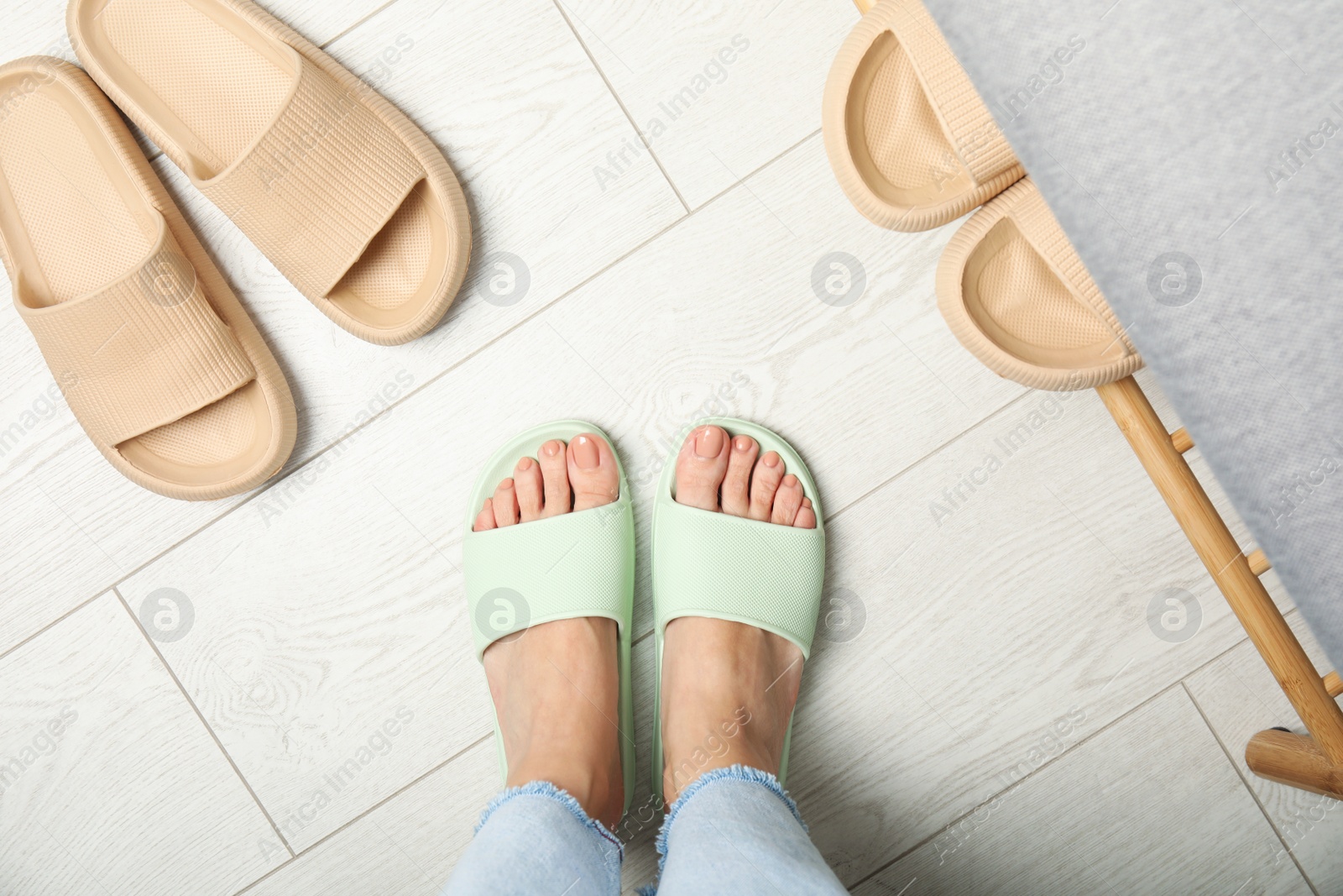 Photo of Woman wearing comfortable rubber slippers indoors, top view