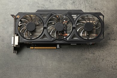 Photo of One computer graphics card on grey textured table, top view. Space for text