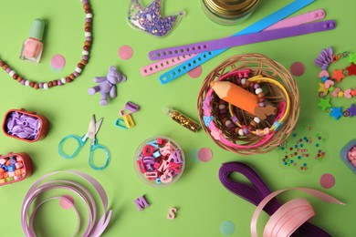 Photo of Handmade jewelry kit for children. Colorful beads, ribbons and supplies on green background, flat lay