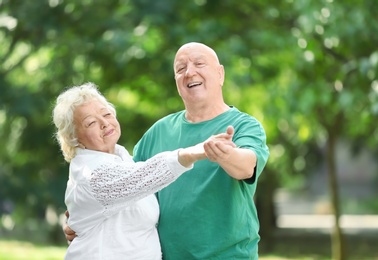 Photo of Cute elderly couple dancing outdoors. Time together