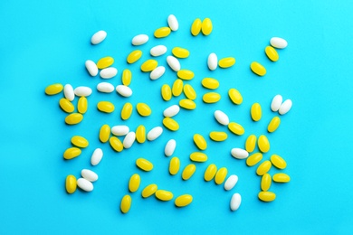 Colorful jelly beans on turquoise background, flat lay