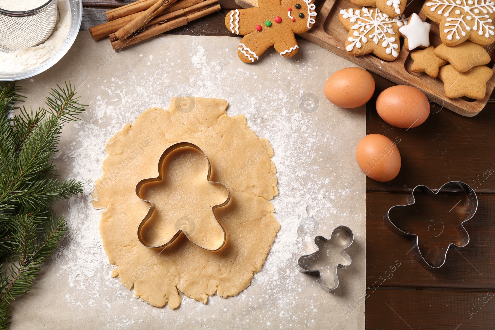 Photo of Making Christmas cookies. Flat lay composition with ingredients and raw dough on wooden table