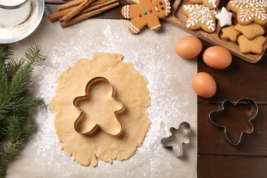 Photo of Making Christmas cookies. Flat lay composition with ingredients and raw dough on wooden table