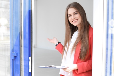 Photo of Beautiful real estate agent with clipboard outdoors