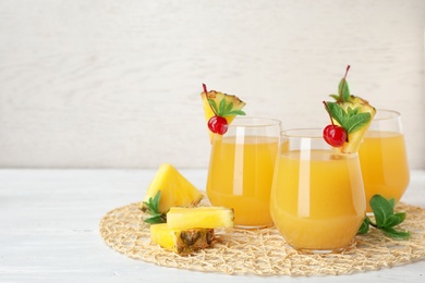 Photo of Glasses with delicious pineapple juice on table