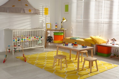 Photo of Cozy baby room interior with comfortable crib