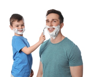 Photo of Little son shaving his dad on white background