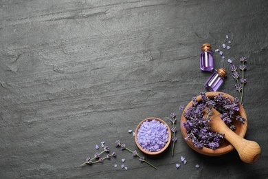 Photo of Cosmetic products and lavender flowers on dark grey background, flat lay. Space for text