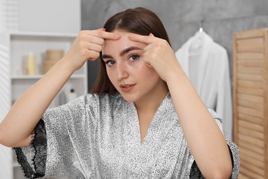 Photo of Young woman with skin problem in bathroom