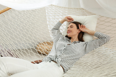 Photo of Happy woman lying in hammock at home
