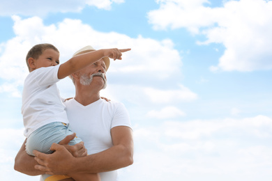 Photo of Grandfather with little boy outdoors in summer