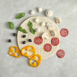 Photo of Flat lay composition with base and ingredients for pizza on marble table