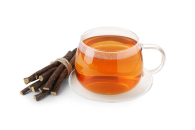 Photo of Aromatic licorice tea in cup and dried sticks of licorice root isolated on white