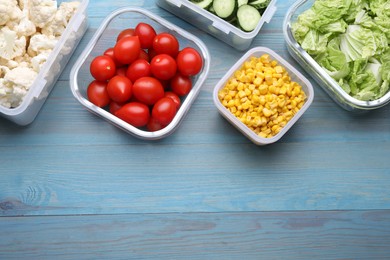 Photo of Plastic and glass containers with different fresh products on light blue wooden table, flat lay. Space for text