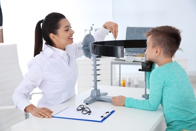 Photo of Children's doctor examining little boy's vision in clinic