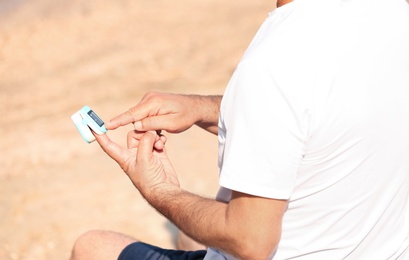 Man checking pulse outdoors on sunny day