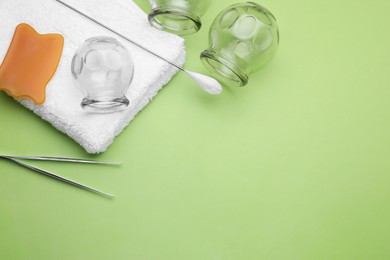 Photo of Flat lay composition with glass cups on light green background, space for text. Cupping therapy