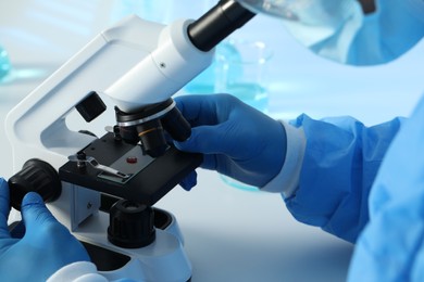 Photo of Scientist working with microscope at table, closeup. Medical research