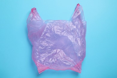 Photo of One plastic bag on light blue background, top view