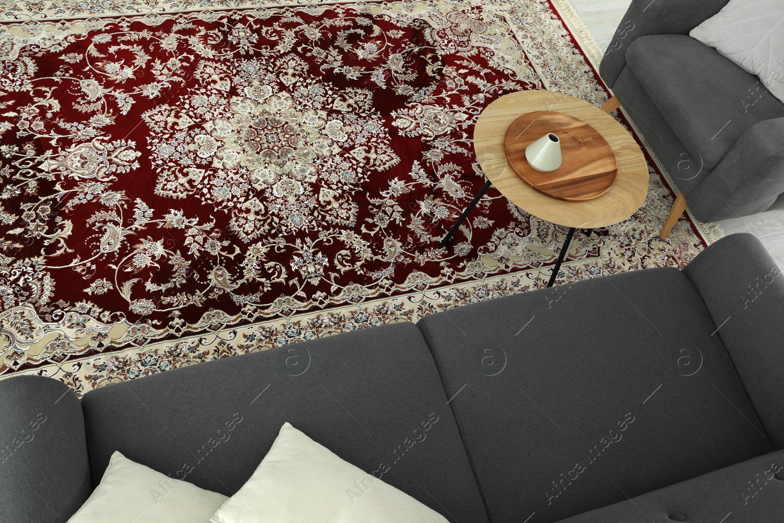 Photo of Cozy room interior with stylish furniture and soft carpet with beautiful pattern, view from above