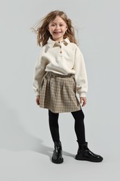 Photo of Fashion concept. Stylish girl posing on light grey background