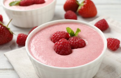 Delicious berry mousse with mint on white wooden table