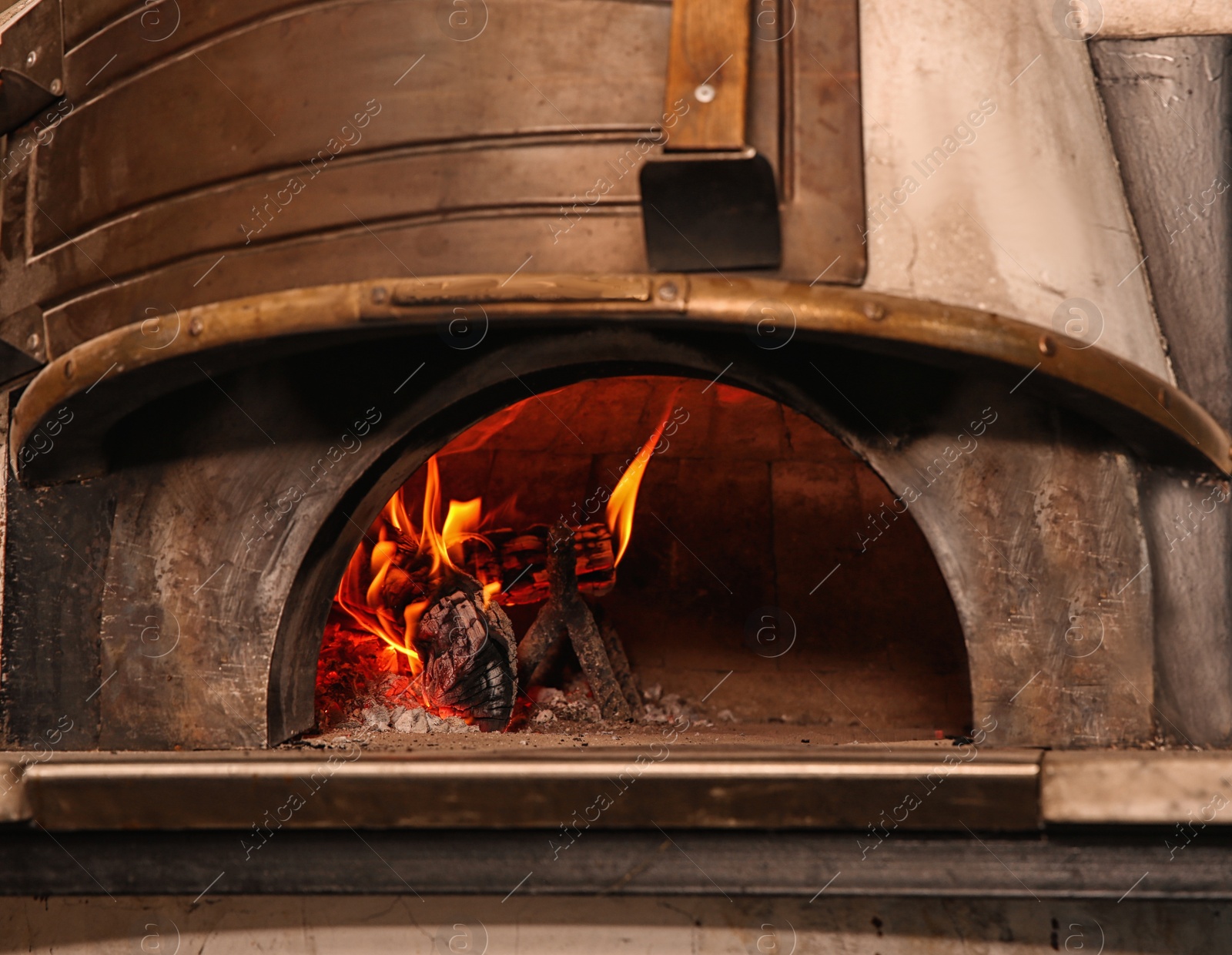 Photo of Oven with burning firewood in restaurant kitchen