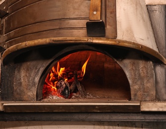 Photo of Oven with burning firewood in restaurant kitchen