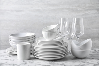Photo of Set of clean dishware on marble table