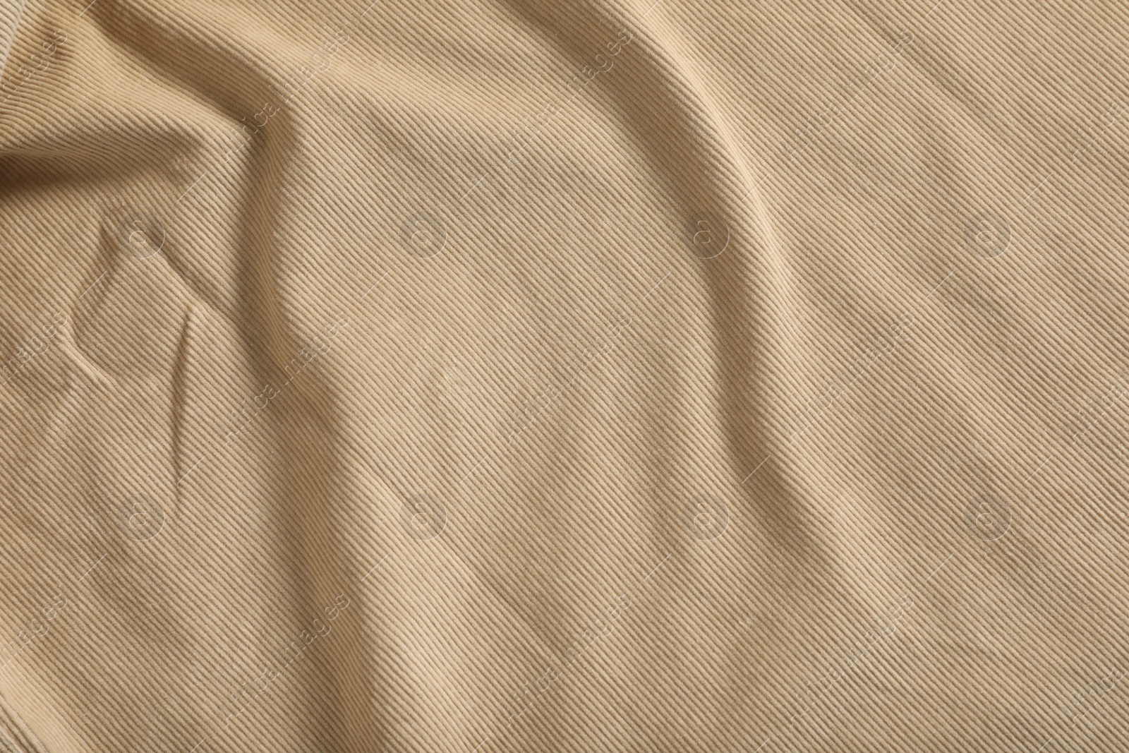 Photo of Crumpled beige fabric as background, top view