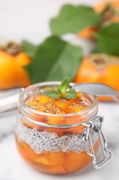 Photo of Delicious dessert with persimmon and chia seeds on table