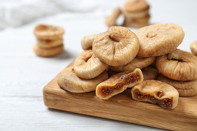 Photo of Tasty dried figs on white wooden table, closeup