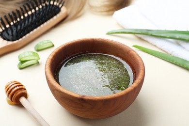 Photo of Homemade hair mask, ingredients and brush on beige background