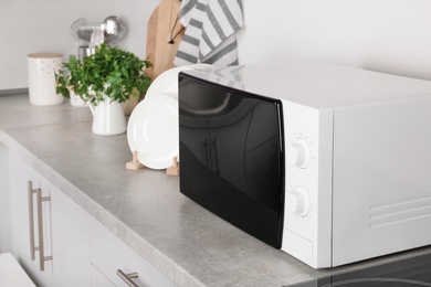 Modern microwave oven on table in kitchen