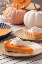 Photo of Fresh homemade pumpkin pie with whipped cream on table