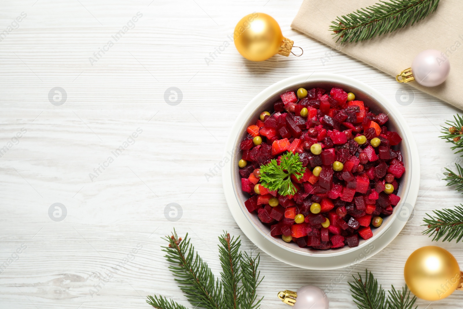 Photo of Traditional Russian vinaigrette salad and Christmas decorations on white wooden table, flat lay. Space for text