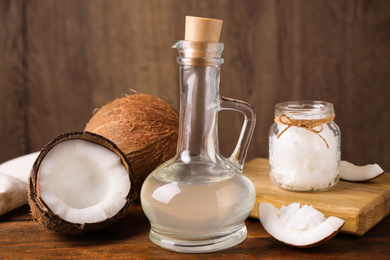 Photo of Coconut oil in glass jug on wooden table