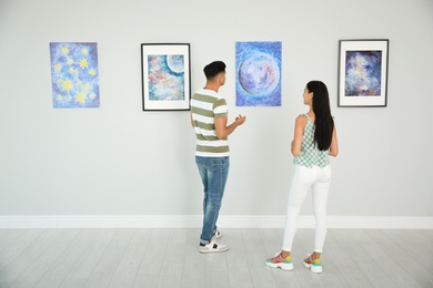 Photo of Man and woman at exhibition in art gallery