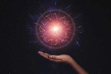 Image of Woman holding illustration of bright star with zodiac wheel around it in open space, closeup