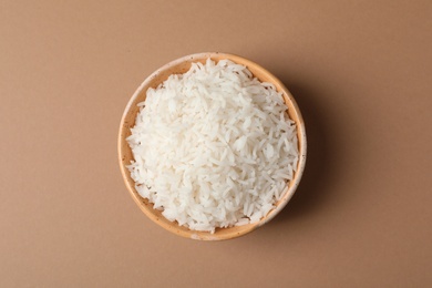 Photo of Bowl of tasty cooked rice on color background, top view
