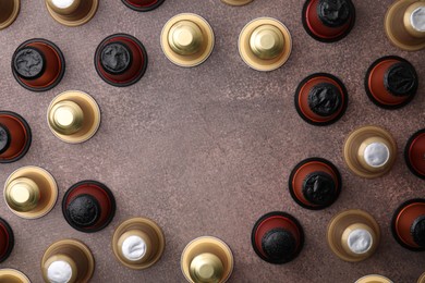 Photo of Many coffee capsules on brown table, flat lay. Space for text