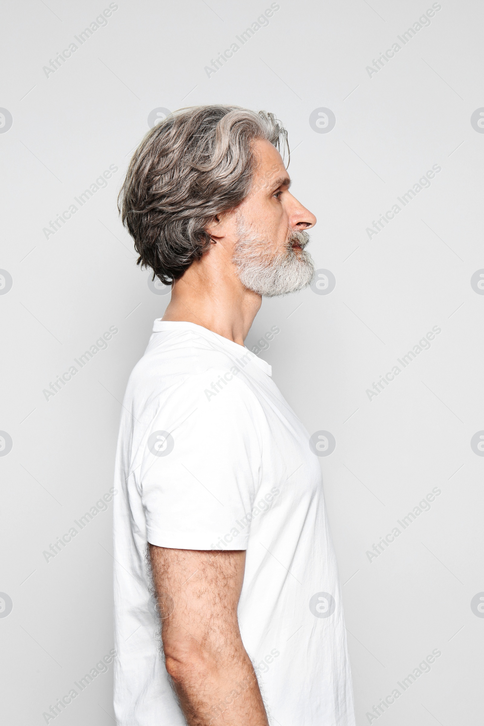 Photo of Portrait of charming mature man on light grey background