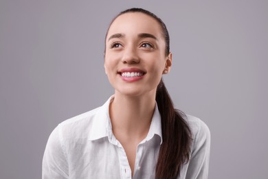 Portrait of happy young woman on light grey background