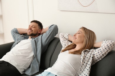 Photo of Couple relaxing on sofa in living room