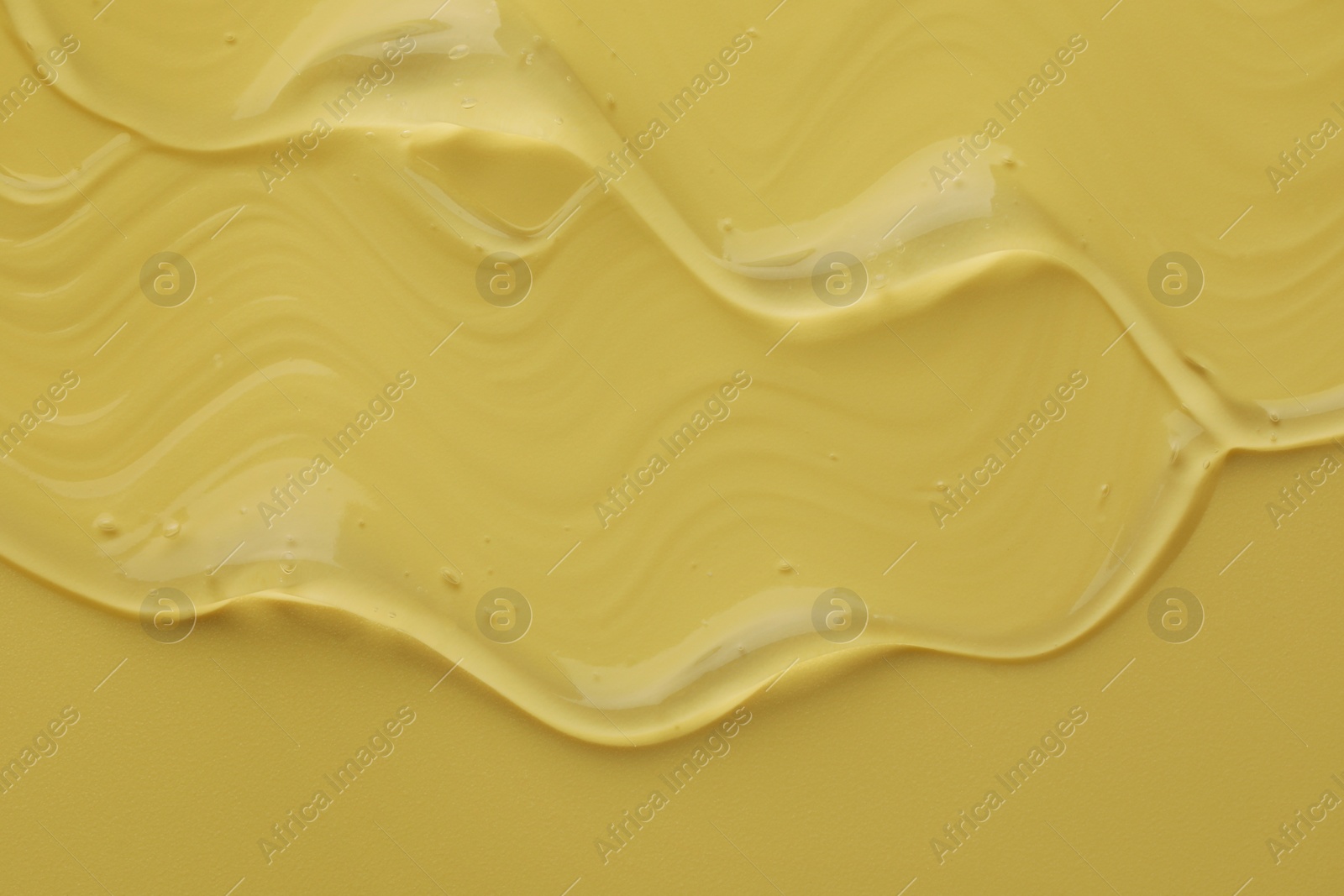 Photo of Clear cosmetic gel on yellow background, top view