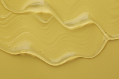 Photo of Clear cosmetic gel on yellow background, top view